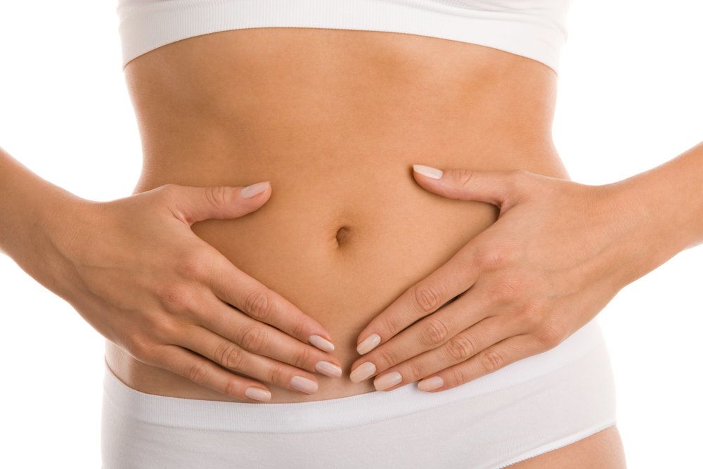 Woman holding hands on sides of bare stomach