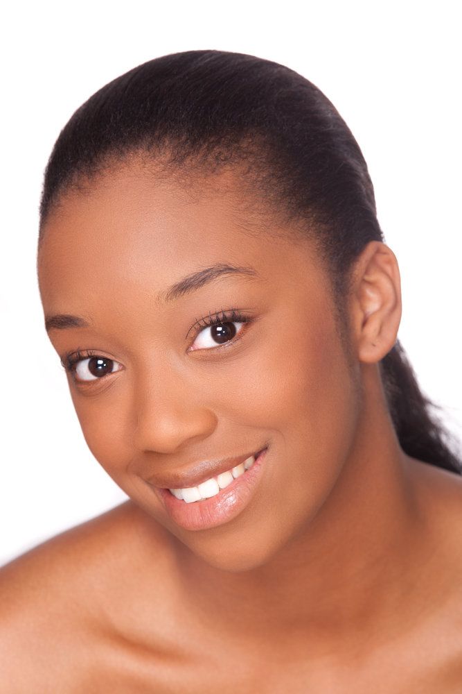 A young woman with dark brown eyes and white teeth smiles at the camera.